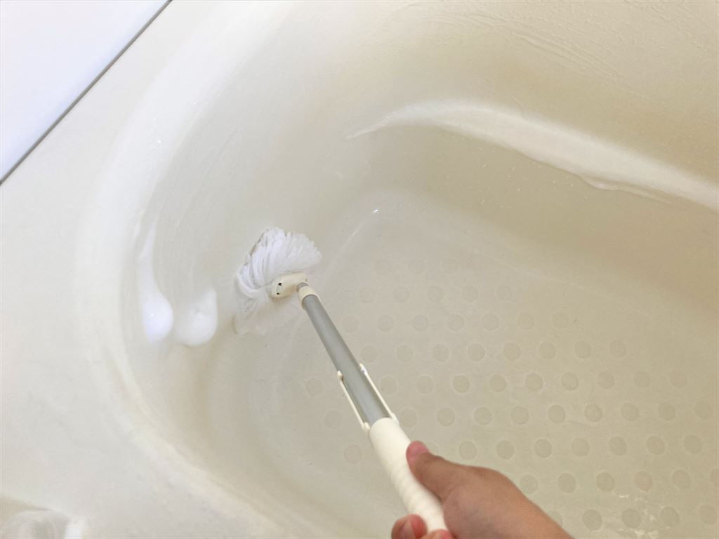 浴槽の内側に洗剤をつけてブラシで洗っている様子
