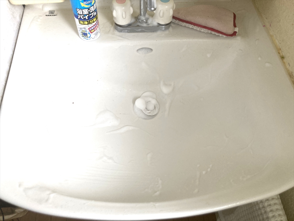 洗面台トレイにバイオサイクル浴室・洗面台・パイプ用（濃密泡タイプ）を塗布し、つけ置きしている様子