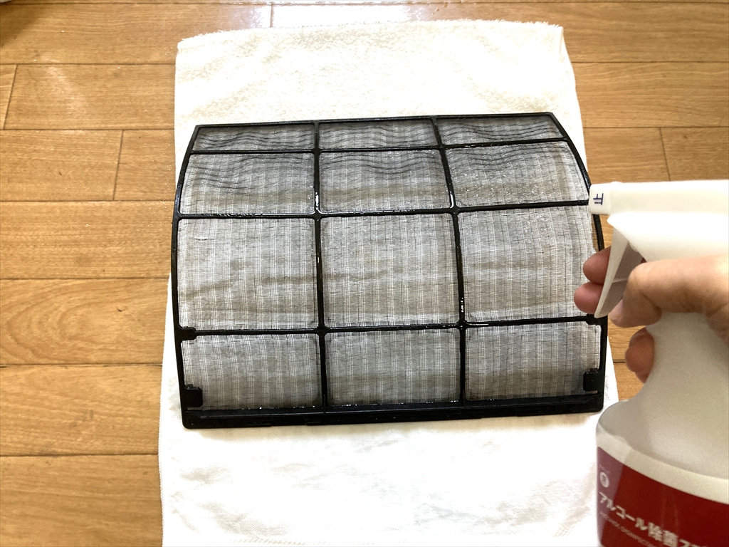 エアコンフィルターにアルコールスプレーを噴射している様子