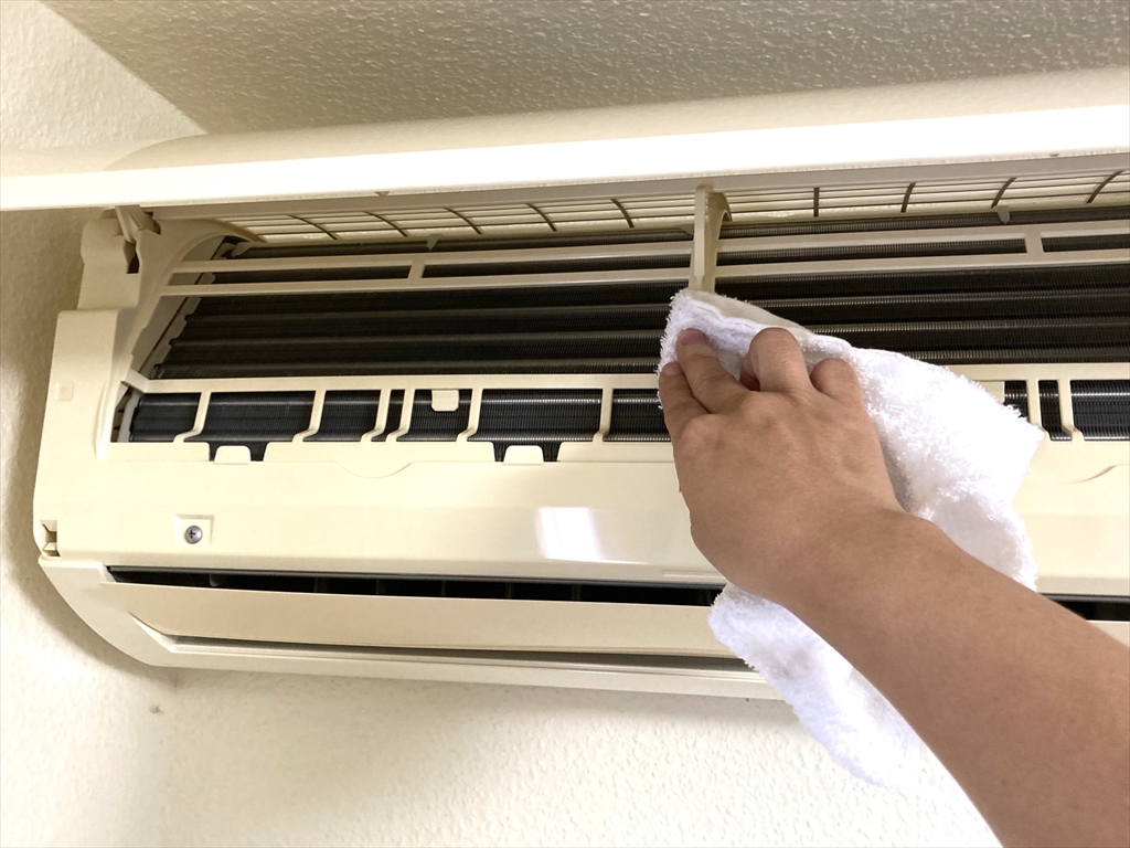 エアコンの吹き出し口をタオルで拭きとっている様子