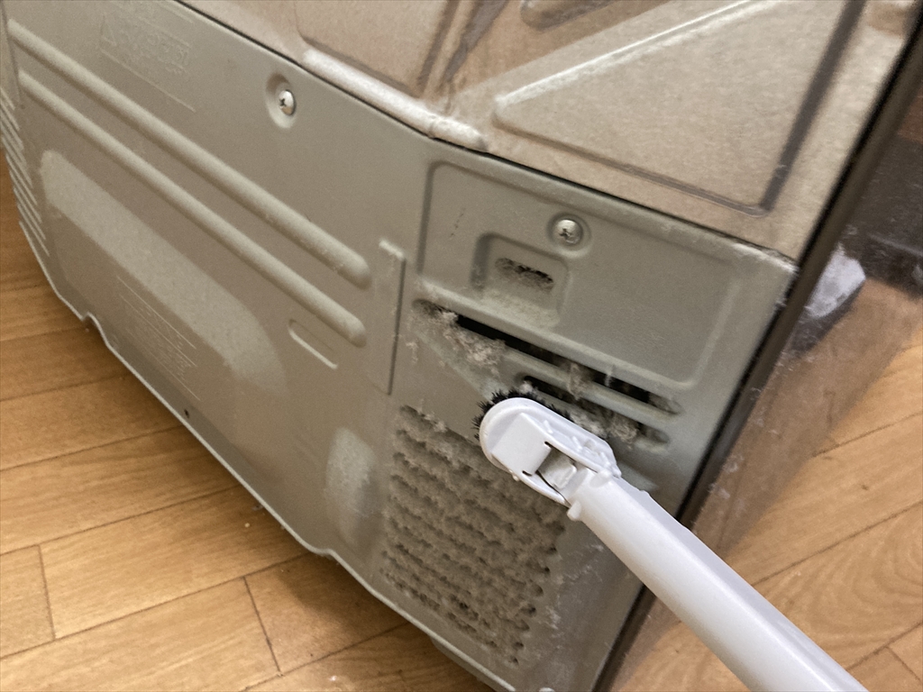 家電の裏側にたまったホコリを掃除している様子