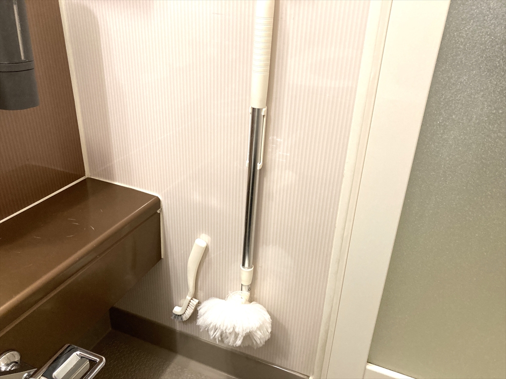 壁に掃除道具を取り付けている様子