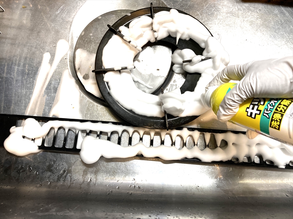 排煙口や五徳にバイオサイクルキッチン用泡タイプを塗布している様子