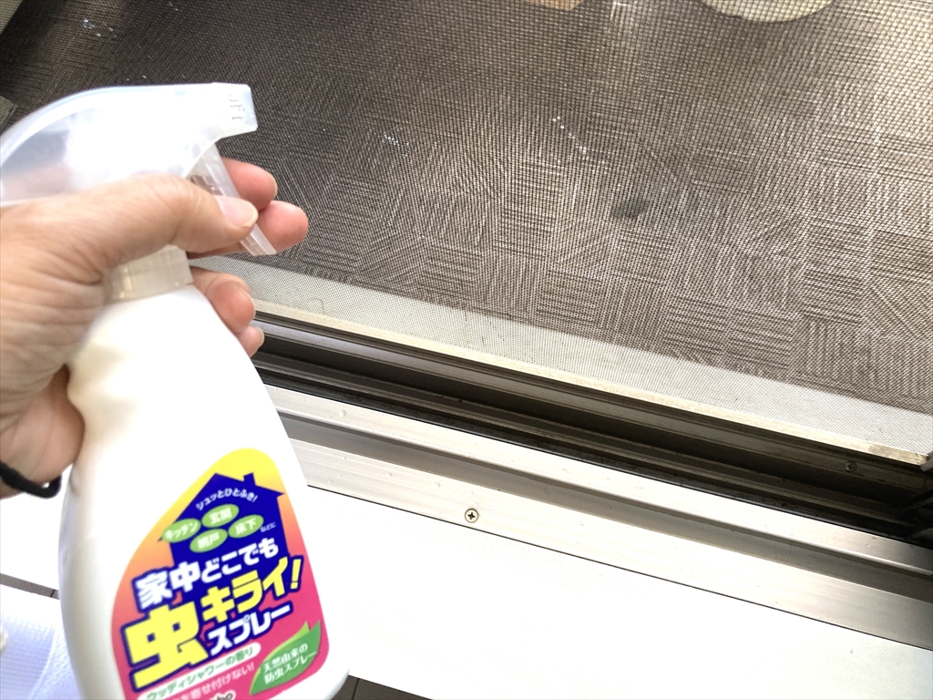 網戸やサッシに虫キライスプレーを噴射している様子