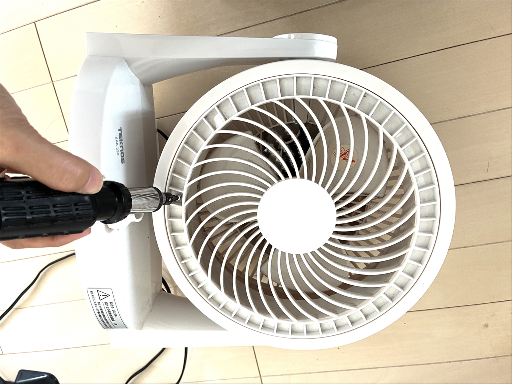 サーキュレーターの前面カバーをドライバーを使って外している様子
