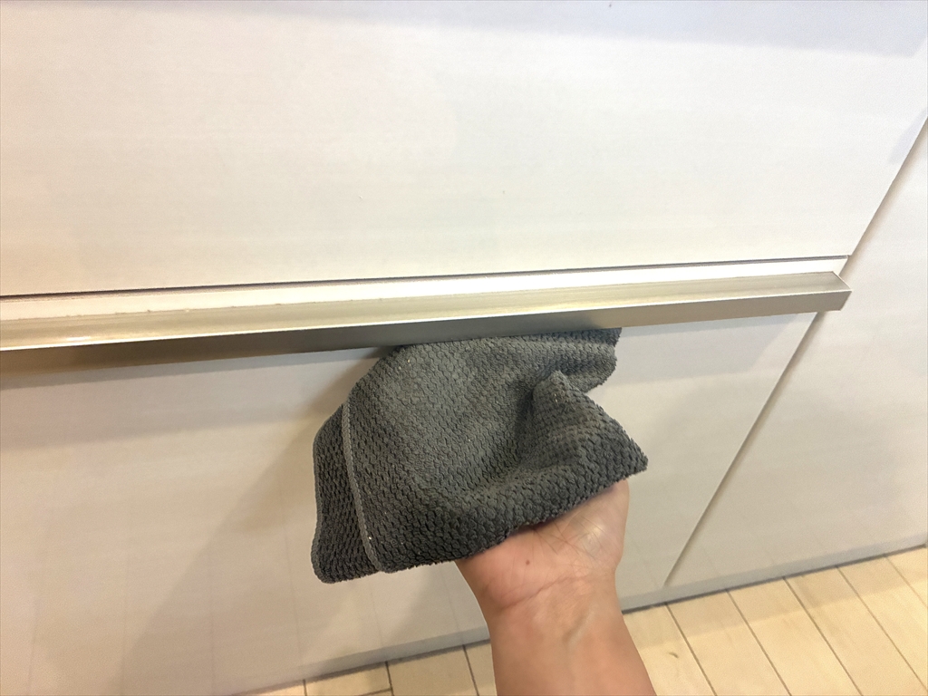 洗剤をしみこませたクロスで取っ手を下から拭いている様子